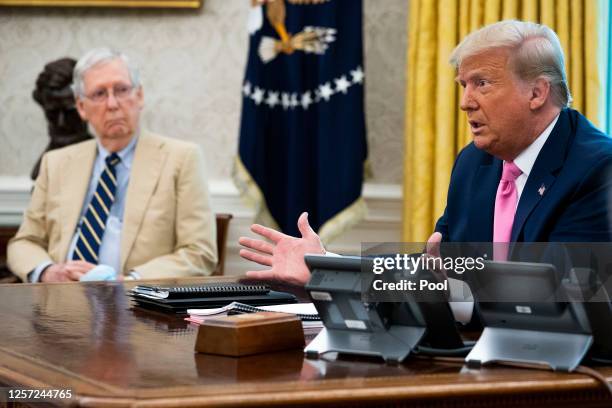 Senate Majority Leader Mitch McConnell listens to U.S. President Donald Trump talks to reporters while hosting Republican congressional leaders and...