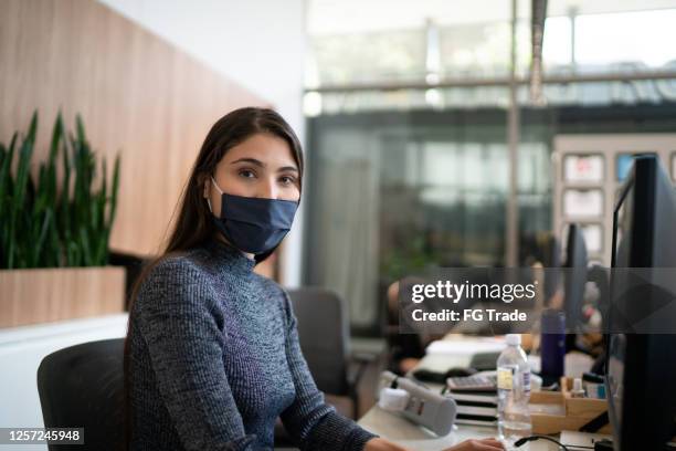 portrait of lobby receptionist wearing face mask - latin america covid stock pictures, royalty-free photos & images