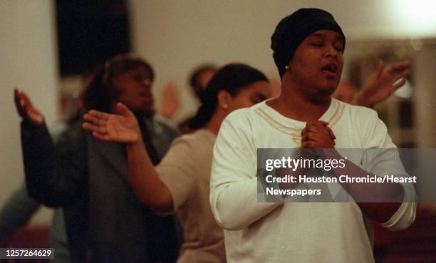 Vanessa Owens, sings along with other members of the Greater New Grove Christian Worship Center congregation, during a Wednesday night service, in...