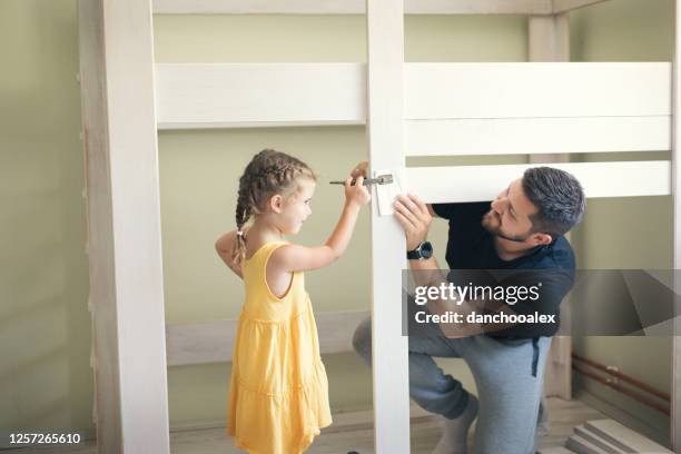 young man with his daughter assembling furniture at home - kids in bunk bed stock pictures, royalty-free photos & images