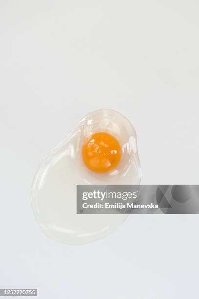 broken egg on white background - spotted egg stock pictures, royalty-free photos & images