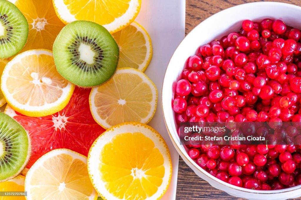 Citrus fruits and red currant in bowl