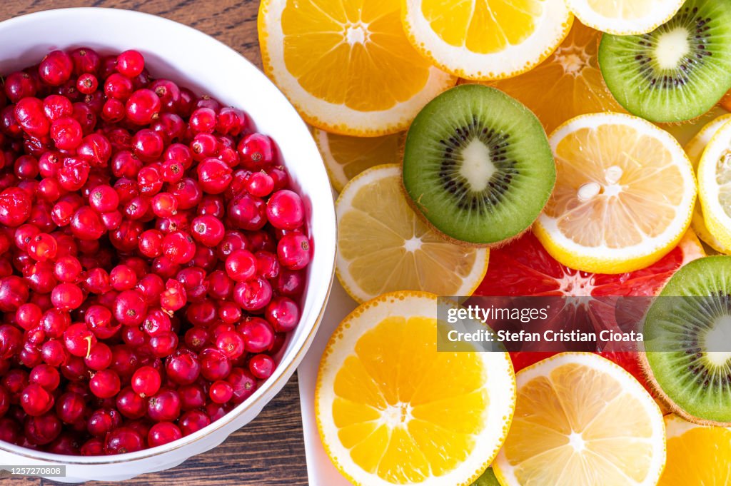 Bowl full of red currant berries near citrus fruits slices