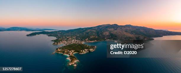 corfu, kerkyra, aerial panoramic photo of the town and port of cassiopeia / kassiopia at summer dusk - corfu town stock pictures, royalty-free photos & images