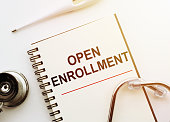 Open Enrollment - words written on notebook with stethoscope on white table, Medical Concept