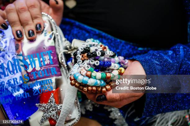 Woman shows off her friendship bracelets that she made while she rides on the commuter line to Gillette Stadium to see Taylor Swift in concert.