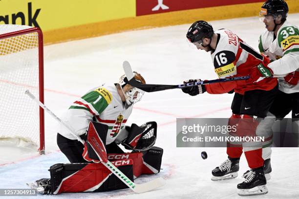 Hungary's defender Milan Horvath attempts to score past Hungary's goalkeeper Bence Balizs and Hungary's forward Daniel Koger during the IIHF Ice...