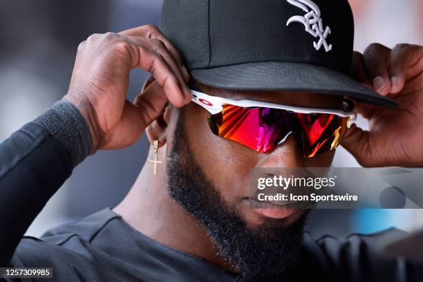 Chicago White Sox center fielder Luis Robert Jr. Puts on his sunglasses in the dugout during an MLB game against the Cleveland Guardians on May 18,...