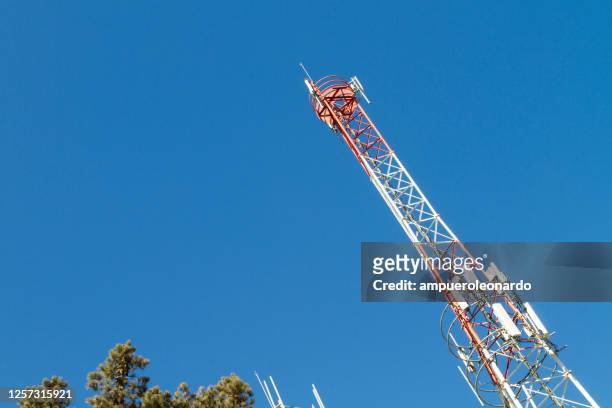 5g cellular telecommunications or cellphone radio tower in a deep blue sky with copy space: cellular communications tower for mobile phone and video data transmission - 4g stock pictures, royalty-free photos & images