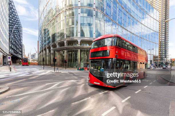 uk, london, red double decker bus # with modern buildings in background - london red bus photos et images de collection