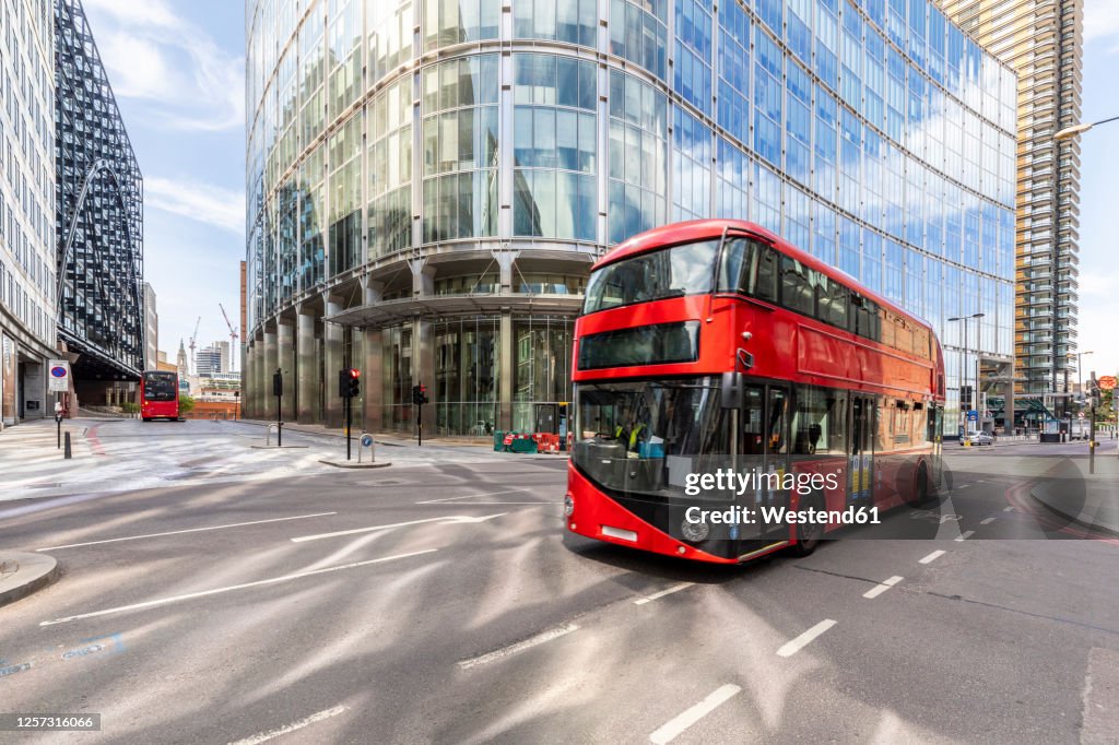 UK, London, Red double decker bus # with modern buildings in background