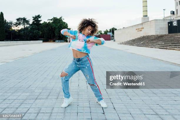young woman dancing on square - hip hop dance fotografías e imágenes de stock