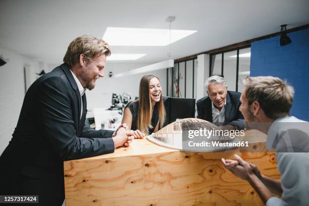 successful business people looking at architectural model in office - architekturmodell stock-fotos und bilder