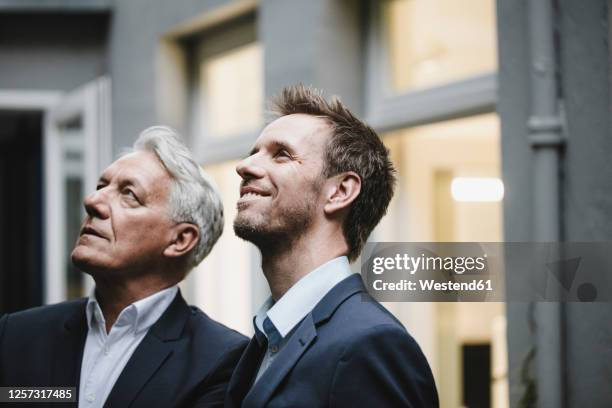 two successful businessmen, looking at up, smiling - mirar hacia arriba fotografías e imágenes de stock