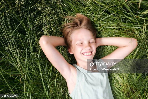 portrait of happy boy with eyes closed lying on a meadow in summer - child eyes closed stock pictures, royalty-free photos & images