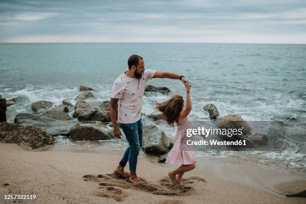 daughter dancing with father at beach - father daughter dance stock-fotos und bilder