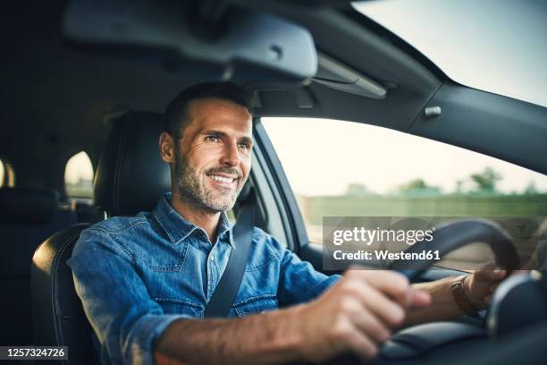 handsome man driving a car - drive car photos et images de collection