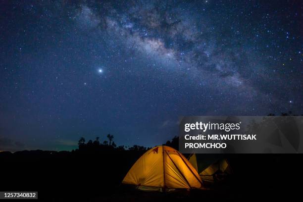 tent camping on mountains at night.milky way.beautiful night sky with stars. - campfire no people stock-fotos und bilder