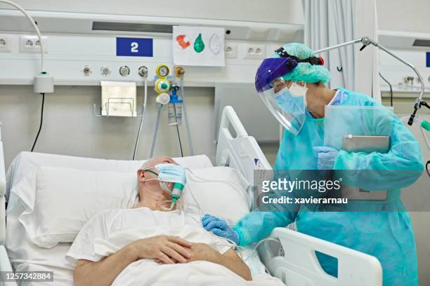 medico donna che sostiene la paziente maschio sdraiata nel letto d'ospedale - incoraggiamento foto e immagini stock