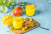 Yellow Indian mango yogurt drink Mango Lassi or smoothie with turmeric and saffron