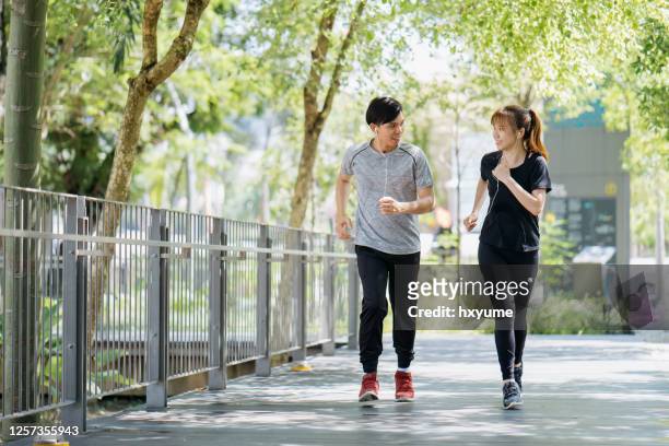 精力充沛的年輕夫婦早上一起在城市公園慢跑。 - hong kong community 個照片及圖片檔
