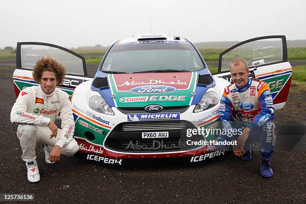 In this handout image supplied by Castrol, Moto GP rider Marco Simoncelli of Italy poses with driver Mikko Hirvonen of Finland during a one-off test...