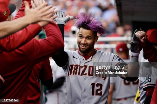 Lourdes Gurriel Jr. #12 of the Arizona Diamondbacks is congratulated in the dugout after hitting a home run during the first inning against the...
