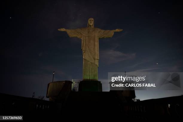 The Christ the Redeemer statue is seen without illumination to condemn racist acts against Brazilian footballer Vinicius Junior in Rio de Janeiro,...