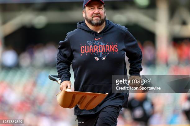 Member of the Cleveland Guardians grounds crew leaves the field after collecting a bird that was struck and killed on the infield by a base hit by...