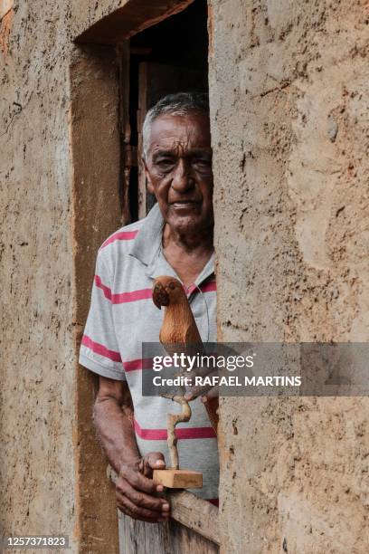 Jose Dantas Narciso poses with a good macaw on his property where he preserves the Licuri palm tree that serves as food for Lear's macaws in Serra...