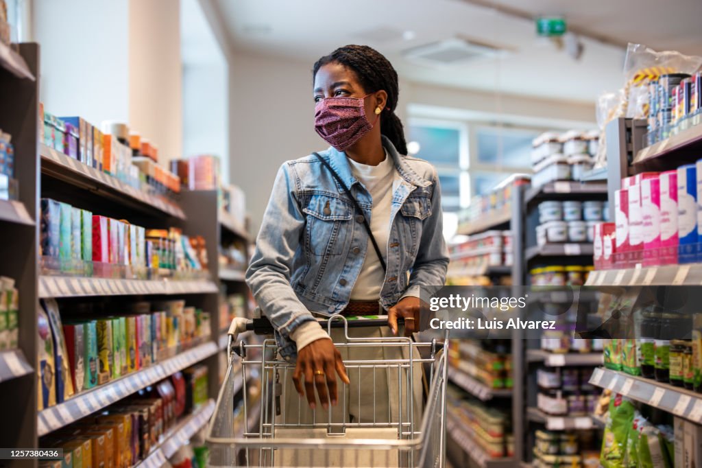Female customer with face mask shopping at a grocery store