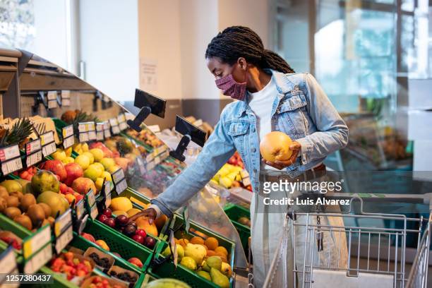 female shopping fruits in grocery shop - obst stock-fotos und bilder