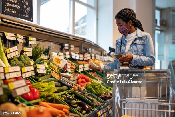 african woman shopping grocery in shop - picking up groceries stock pictures, royalty-free photos & images