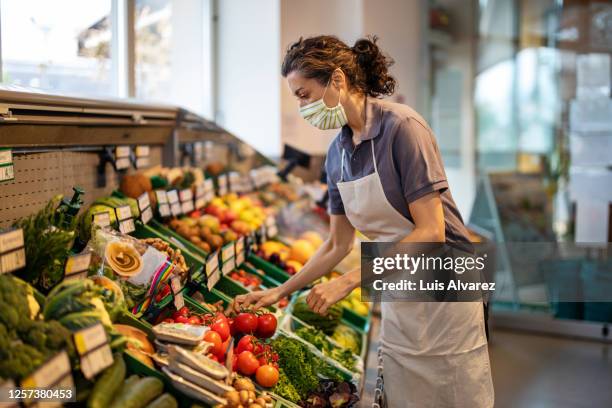 female staff working in produce section of supermarket - produce aisle stock pictures, royalty-free photos & images
