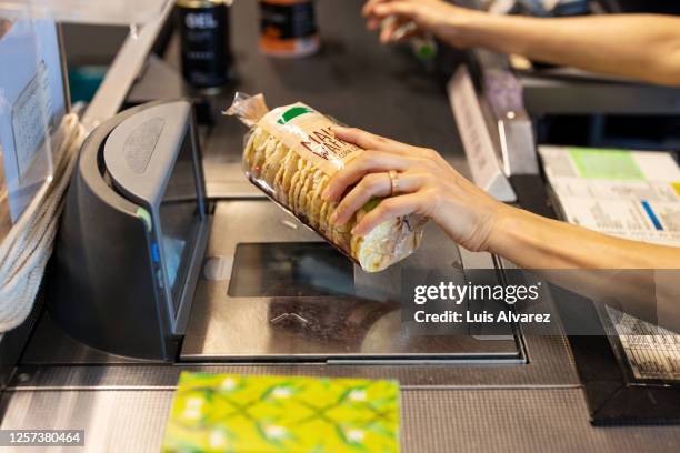 sales clerk scanning the products at supermarket checkout - scanner stock stockfoto's en -beelden