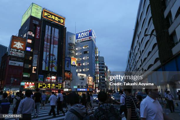 Pedestrians wearing protective masks cross a road in front of Ikebukuro Station on July 21, 2020 in Tokyo, Japan. Tokyo confirmed 237 new COVID-19...