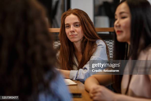 aufmerksame frauen beim treffen im büro - round table discussion stock-fotos und bilder