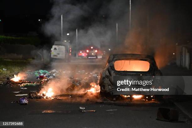 An automobile burns on Highmead Road during unrest following a serious road crash earlier on Snowden Road on May 23, 2023 in Cardiff, Wales. Riot...