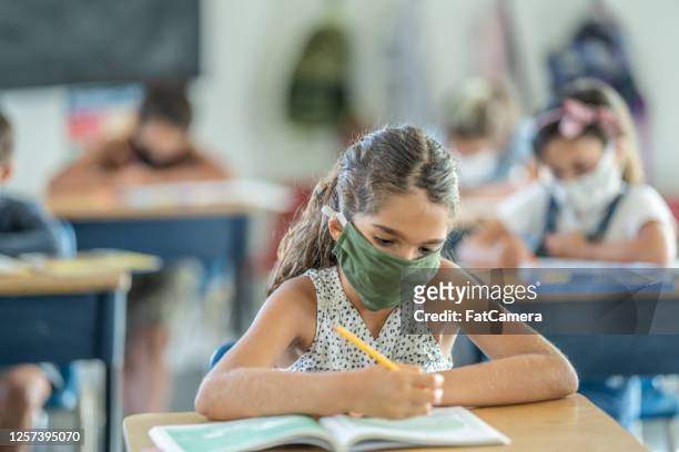 young female student wearing a protective face mask in the classroom - venezuelans stock pictures, royalty-free photos & images