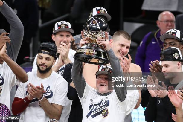 Denver Nuggets coach Michael Malone raises the the Western Conference Finals trophy during game 4 of the NBA Western Conference between the Denver...