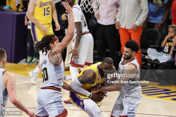 Los Angeles Lakers forward LeBron James gets tied up on his last shot of the game by Denver Nuggets guard Jamal Murray during game 4 of the NBA...