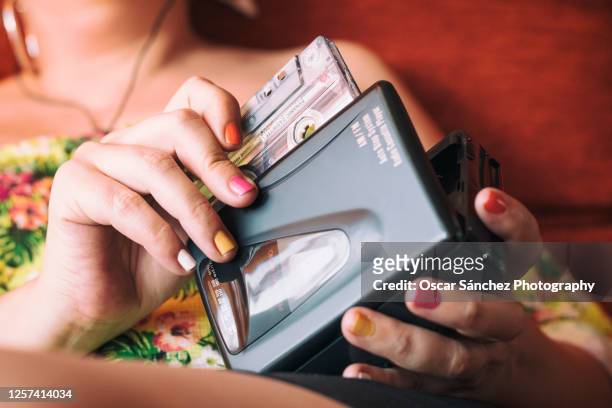 close-up of a woman inserting a cassette tape into a 80s personal player - audio cassettes photos et images de collection