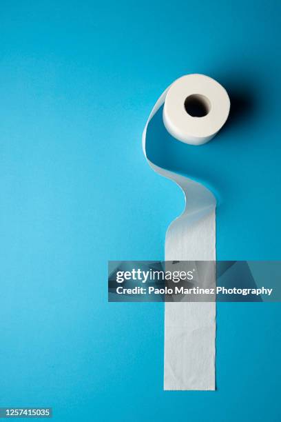roll of toilet paper on a blue background - toilet paper stock pictures, royalty-free photos & images
