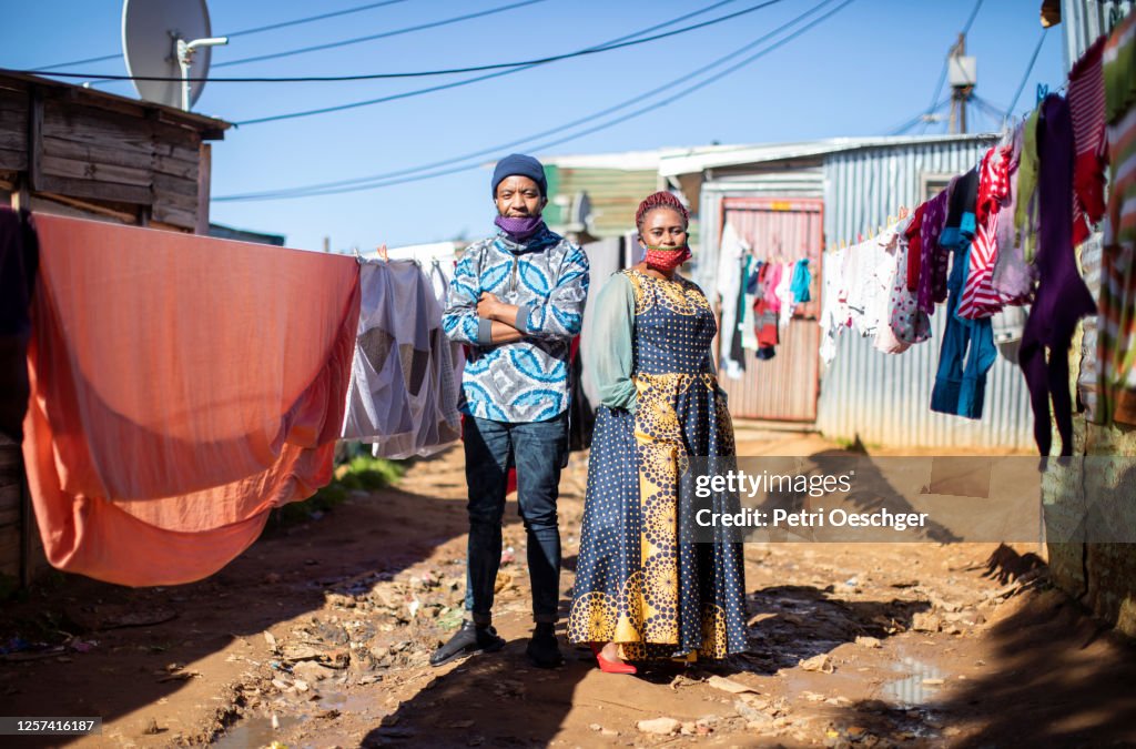 Een Afrikaanse man en een vrouw die aan het werk in township Kayamandi lopen.