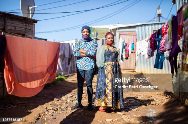 an african man and woman walking to work in kayamandi township. - slum stock pictures, royalty-free photos & images