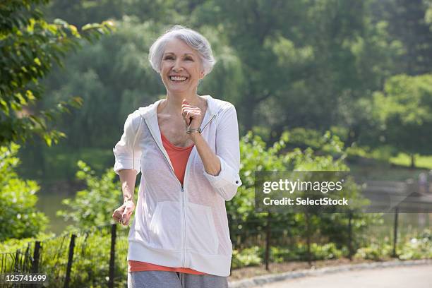 elderly woman jogging in the park - senior woman walking stock pictures, royalty-free photos & images