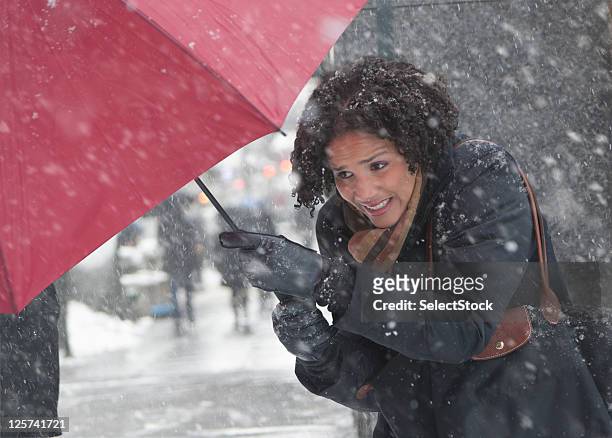 young woman walking in a snow storm - winter storm stock pictures, royalty-free photos & images