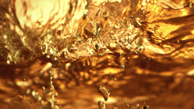 Ice cube in a drink dramatic close-up in slow motion