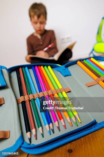 Symbolic photo for doing homework at home. A boy is sitting on the floor and doing homework on May 19, 2023 in Berlin, Germany.