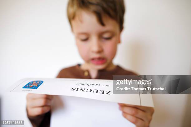 Symbolic photo on the subject of testimonials in elementary school. A boy poses with a certificate on May 19, 2023 in Berlin, Germany.